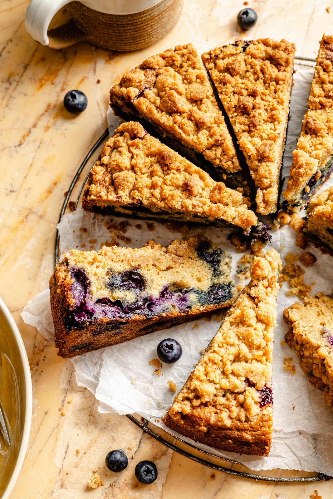 blueberry coffee cake cut into slices on parchment paper