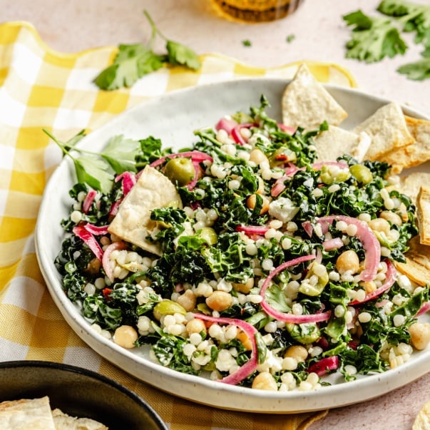 kale couscous salad on a plate with pita chips