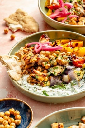 grilled mediterranean chicken and vegetables in a bowl with tzatziki sauce