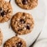 healthy oatmeal chocolate chip cookies on a cooling rack with sea salt on the side
