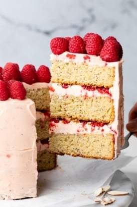 pulling a slice of lemon raspberry cake out of the cake